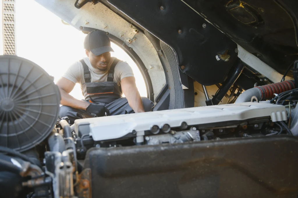 Heavy-duty mechanic inspecting engine components during truck repair at Rusted Nuts Mechanical Services