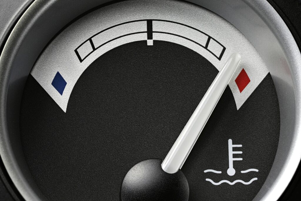 Mechanic inspecting a truck engine after overheating caused head gasket and piston damage